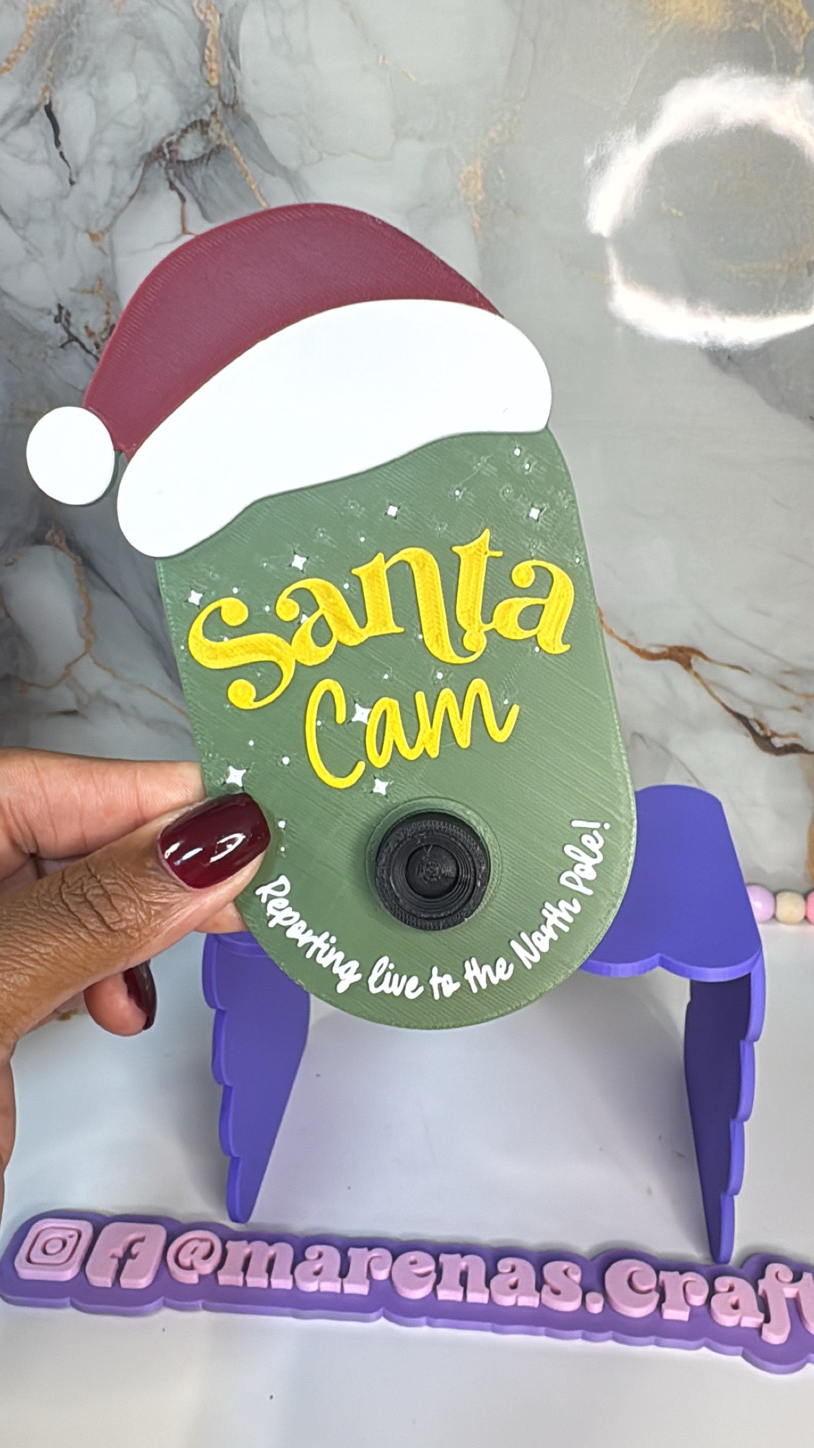 Santa Cam verde pequeña con gorro navideño y letras amarillas, hecha en impresión 3D